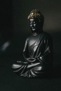 Black Buddha statue with golden details, shows how we can maintain our peace through meditation.