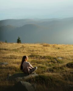 Person sitting on rock in nature.